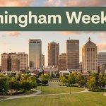 Birmingham’s skyline rises beyond Railroad Park trees and paths beneath a weekend travel banner.