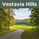 A paved trail leads through trees toward a sunny meadow beneath a Vestavia Hills header.