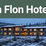 A snowy Flin Flon hotel glowing warmly among evergreens at blue hour.
