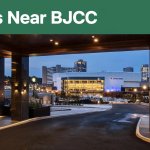 BJCC Legacy Arena glowing downtown Birmingham at blue hour, viewed from a hotel entrance.