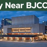 BJCC Concert Hall lit at blue hour with a nearby hotel entrance in the background.