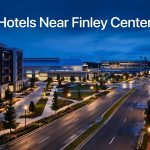The Finley Center glowing beyond modern hotels and landscaped grounds at blue hour.