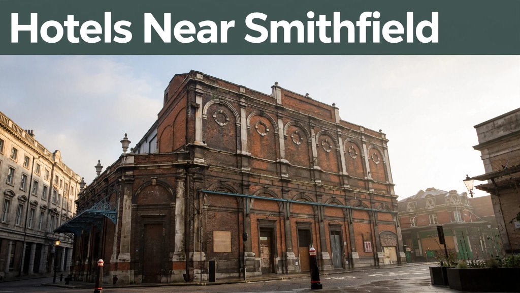 Historic red-brick Smithfield Market buildings beneath a green banner in morning light.