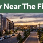 Toyota Field shines beyond nearby hotels at sunset under a green Stay Near The Field banner.