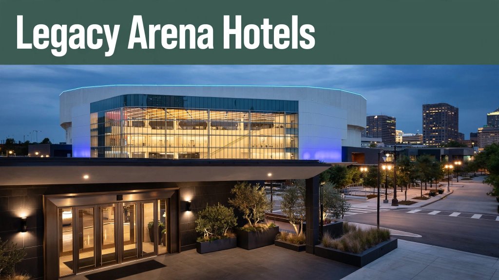 Illuminated Legacy Arena seen from a Birmingham hotel entrance at blue hour.
