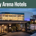 Illuminated Legacy Arena seen from a Birmingham hotel entrance at blue hour.