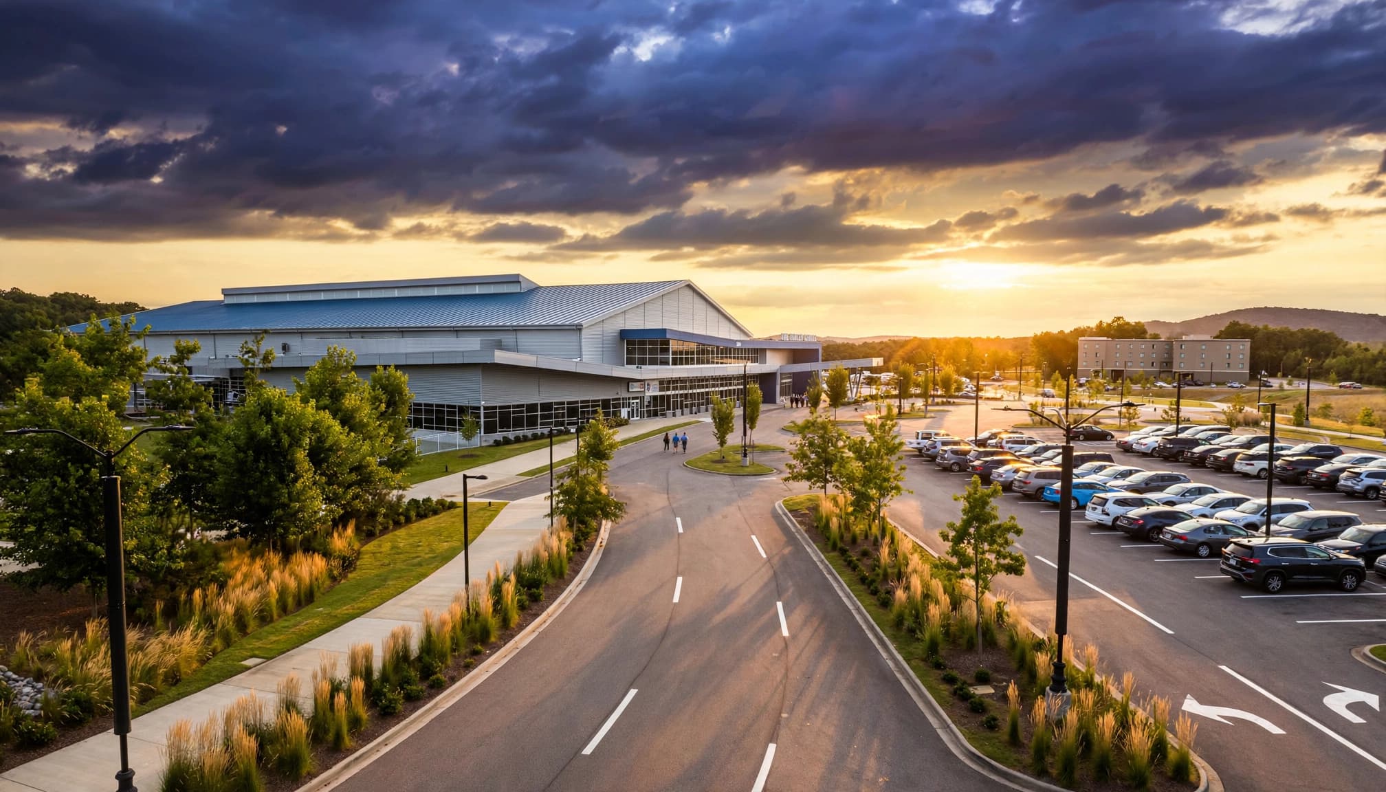 A modern event center and distant hotel beside landscaped roads in Hoover, Alabama.
