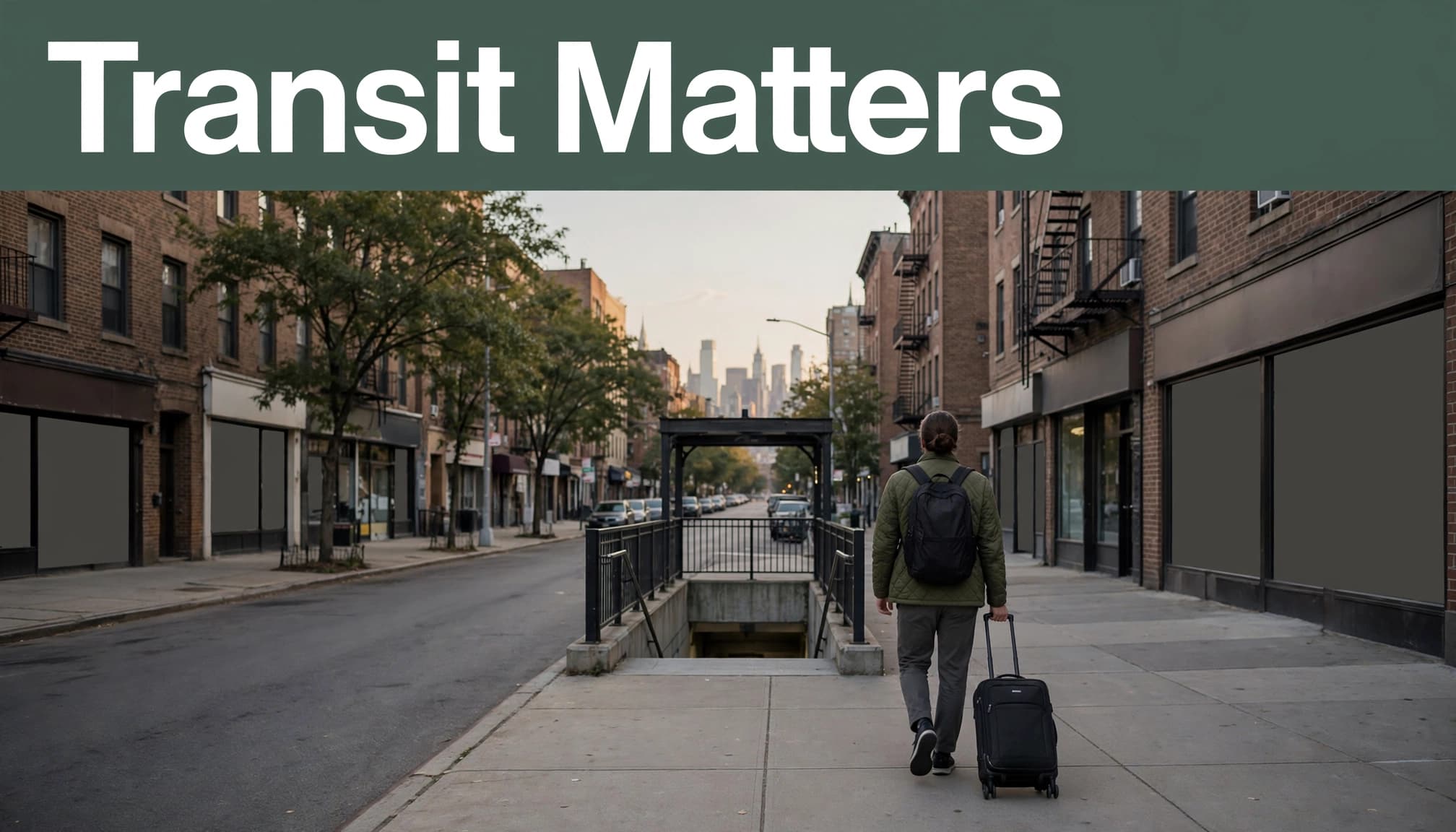 A traveler with a suitcase walks toward transit on a Jersey City sidewalk.