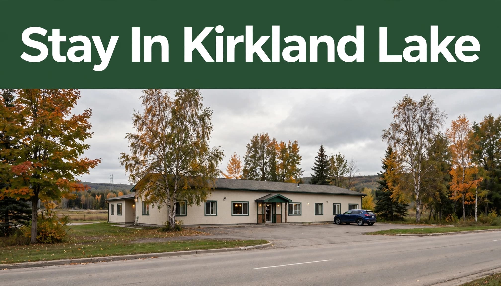 A roadside hotel with one parked car and trees in Kirkland Lake.