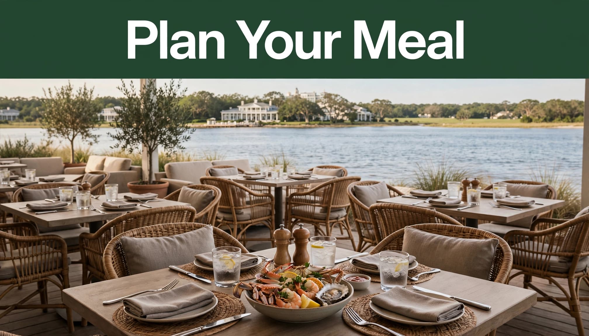 A waterfront patio table with Gulf seafood overlooks Mobile Bay and a green shoreline.